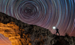 Circumpolar trazas de estrellas startrails sobre un arco de piedra natural. Fotografía nocturna