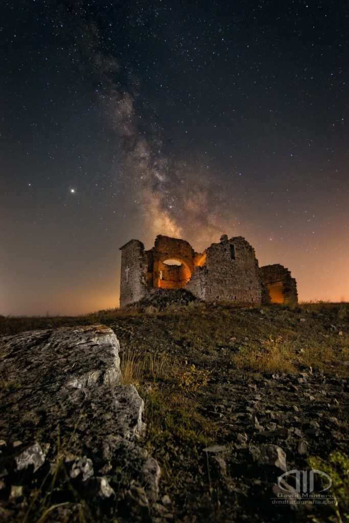 Fotografía Nocturna de larga exposición donde se muestra las ruinas de la ermita de Santa Ana y la vía láctea