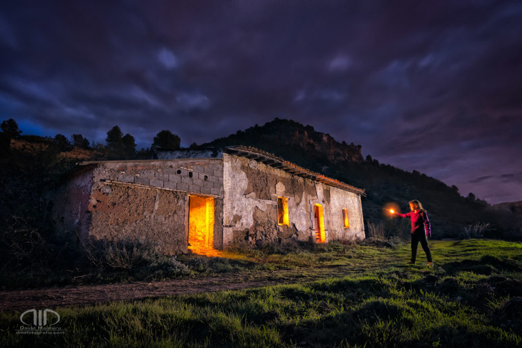 Fotografía nocturna de larga exposición de casa abandonada en las montañas con modelo