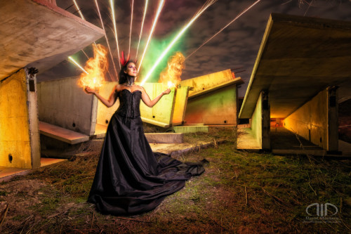 Fotografía de larga exposición nocturna y lightpainting. Modelo con efecto de fuego y fuegos artificiales